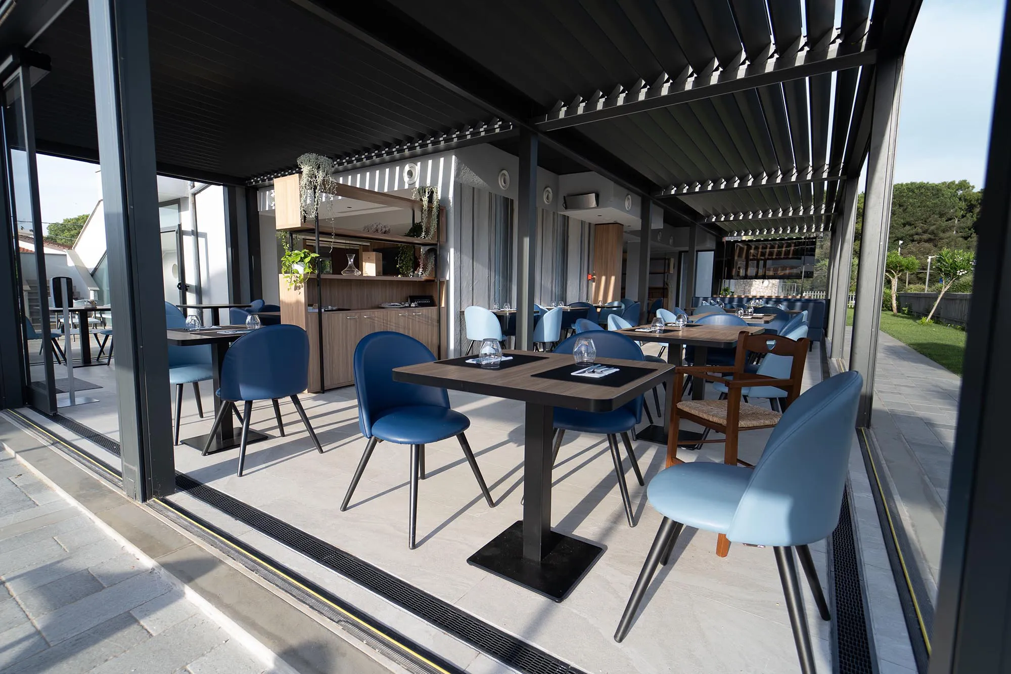 Nell'immagine una parte del ristorante allestita con tavoli e sedie e apparecchiata per gli ospiti.
