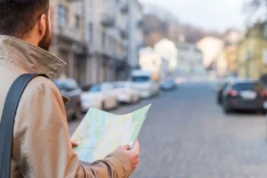 Nell'immagine un ragazzo con una cartina geografica in mano che visita la città.